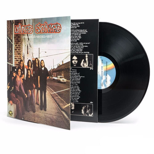 Vinyl record with cover featuring a group of people on a street, on a white background. LYNYRD SKYNYRD